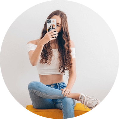 足を組み、スマホを見ながら首を傾ける女性の画像